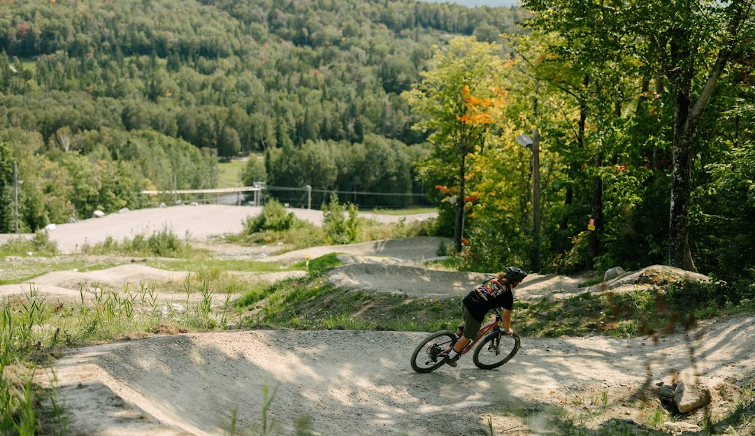 A mountain bike is prominently featured in the beautiful landscape of Mont Adstock in Quebec Canada with hints of a ski resort and winter sports activity.