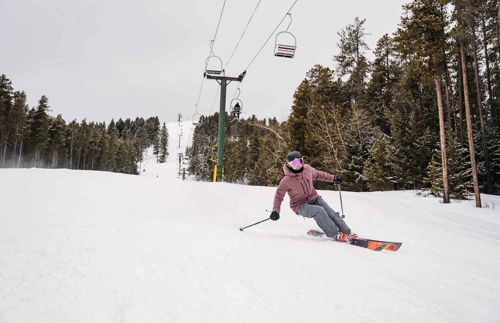 Bear Paw Ski Bowl in USA - a man riding a ski board down a snow covered slope.