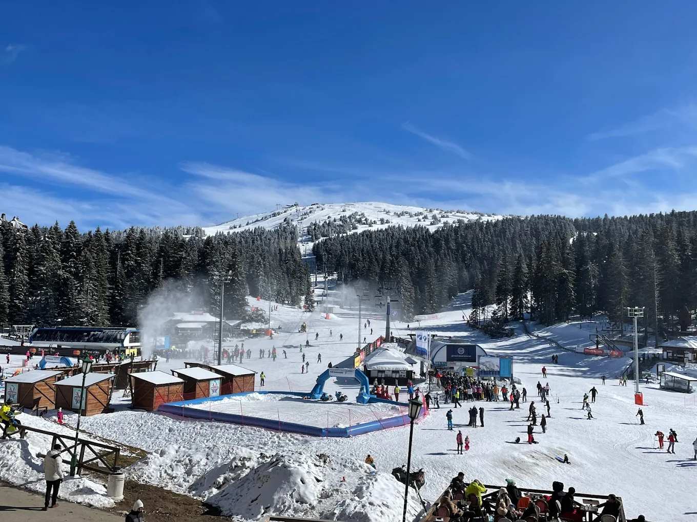 Kopaonik in Serbia - a group of people standing on top of a snow covered slope.