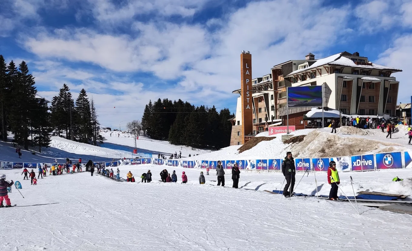 Kopaonik in Serbia - a group of people skiing down a snow covered slope.