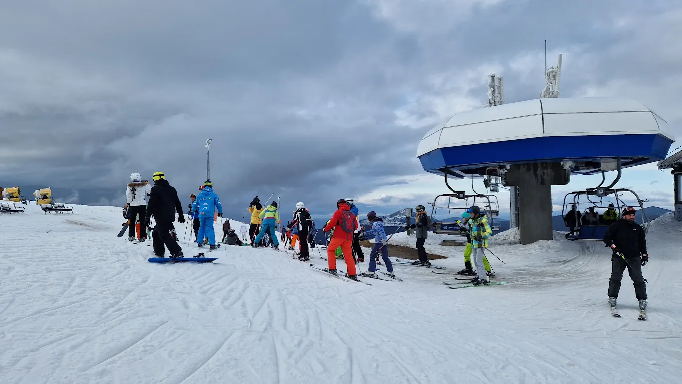 Kopaonik in Serbia - a group of people standing on top of a ski slope.