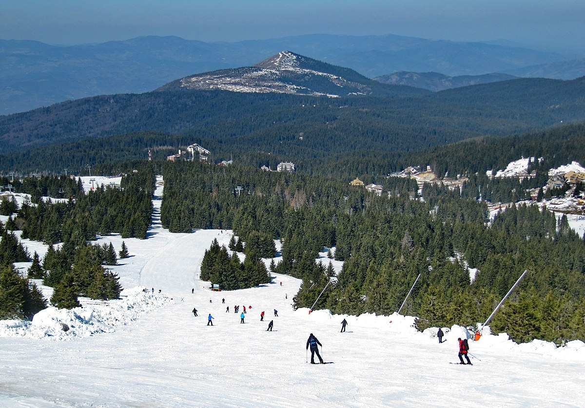 Kopaonik in Serbia - a group of people skiing down a snowy slope.
