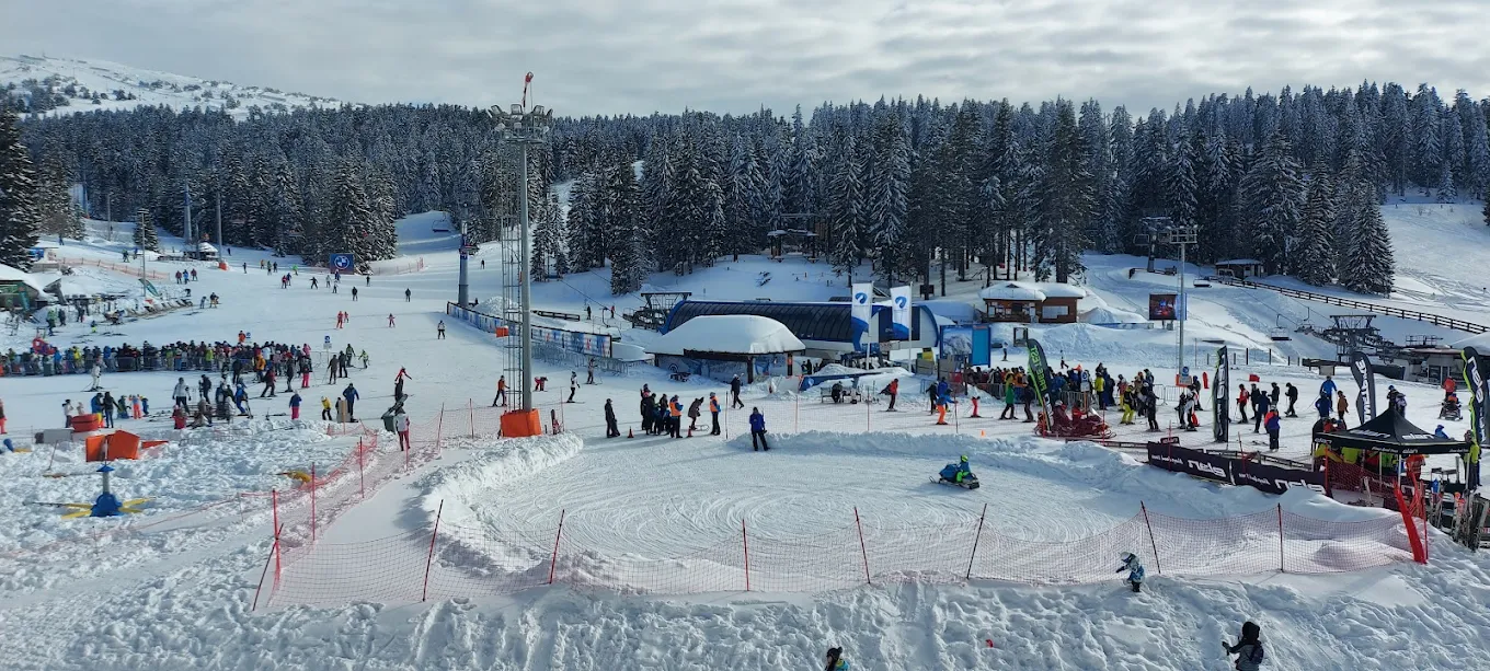 Kopaonik in Serbia - a group of people standing on top of a ski slope.