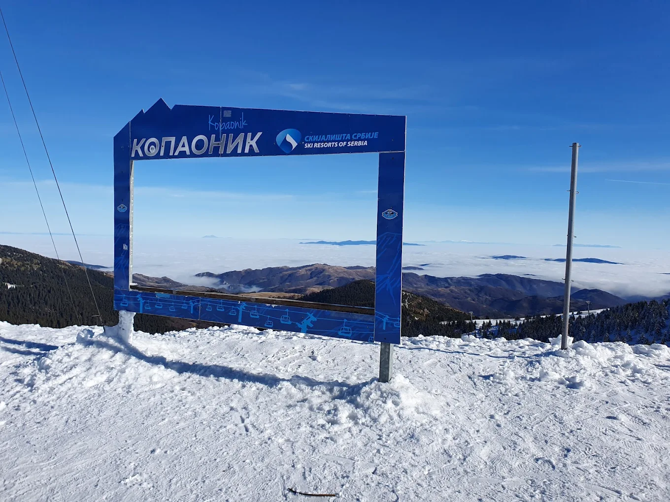 Kopaonik in Serbia - a sign on top of a snow covered mountain.