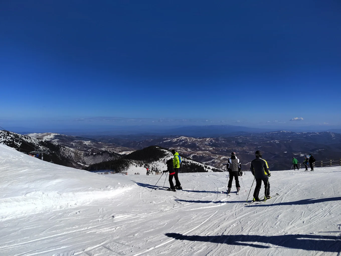 Kopaonik in Serbia - a group of people skiing down a mountain.