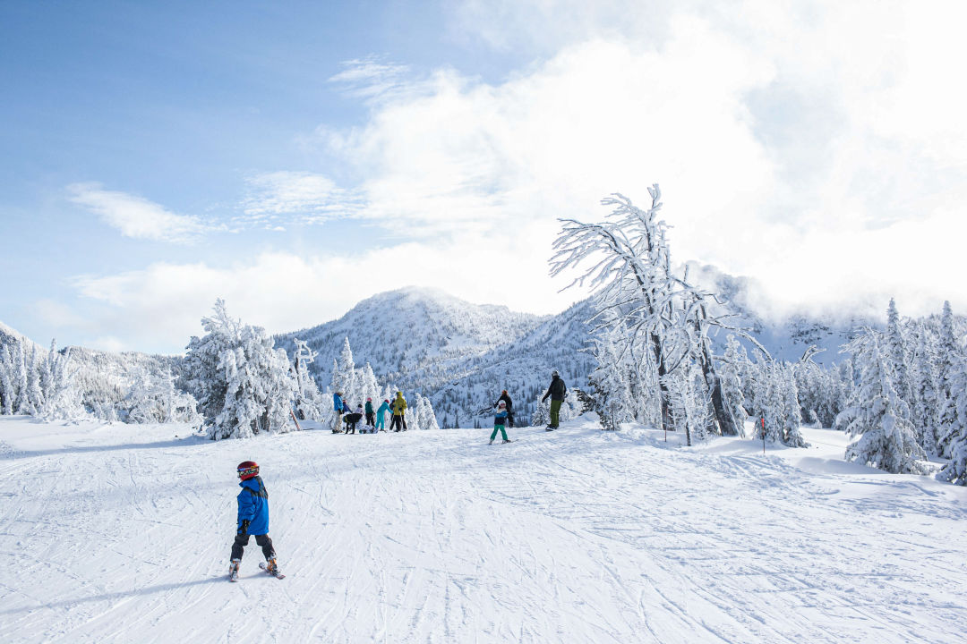 Anthony Lakes Mountain Resort in USA - a group of people skiing down a snowy slope.
