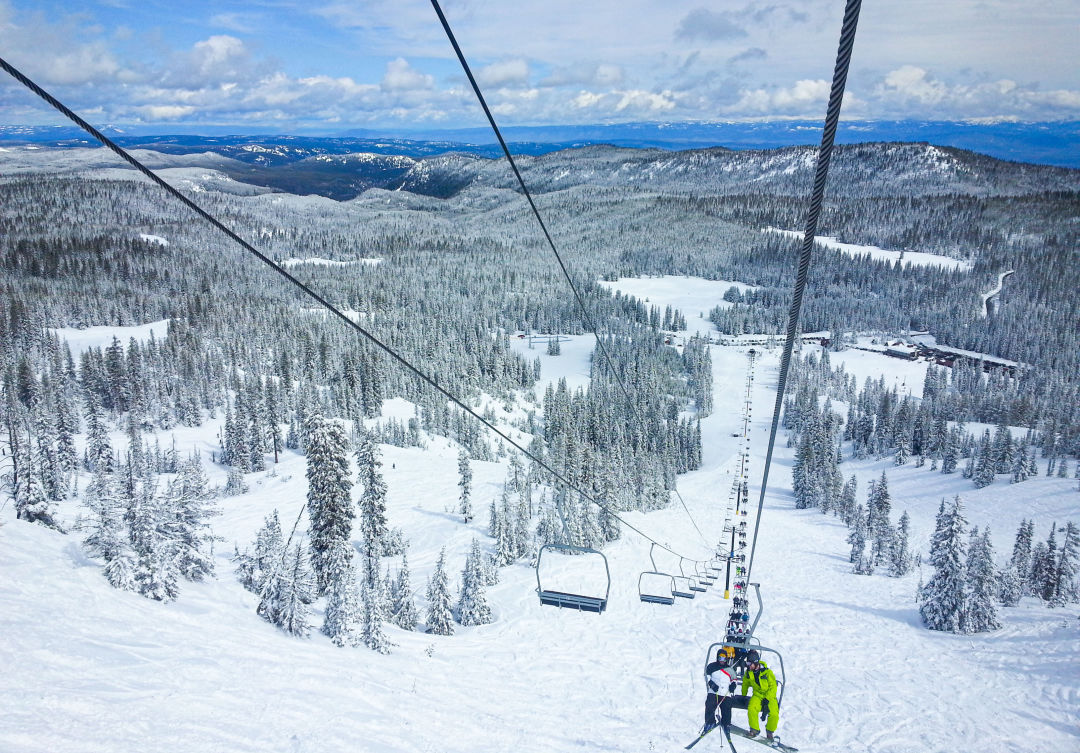 Anthony Lakes Mountain Resort in USA - a person riding a ski lift in the mountains.