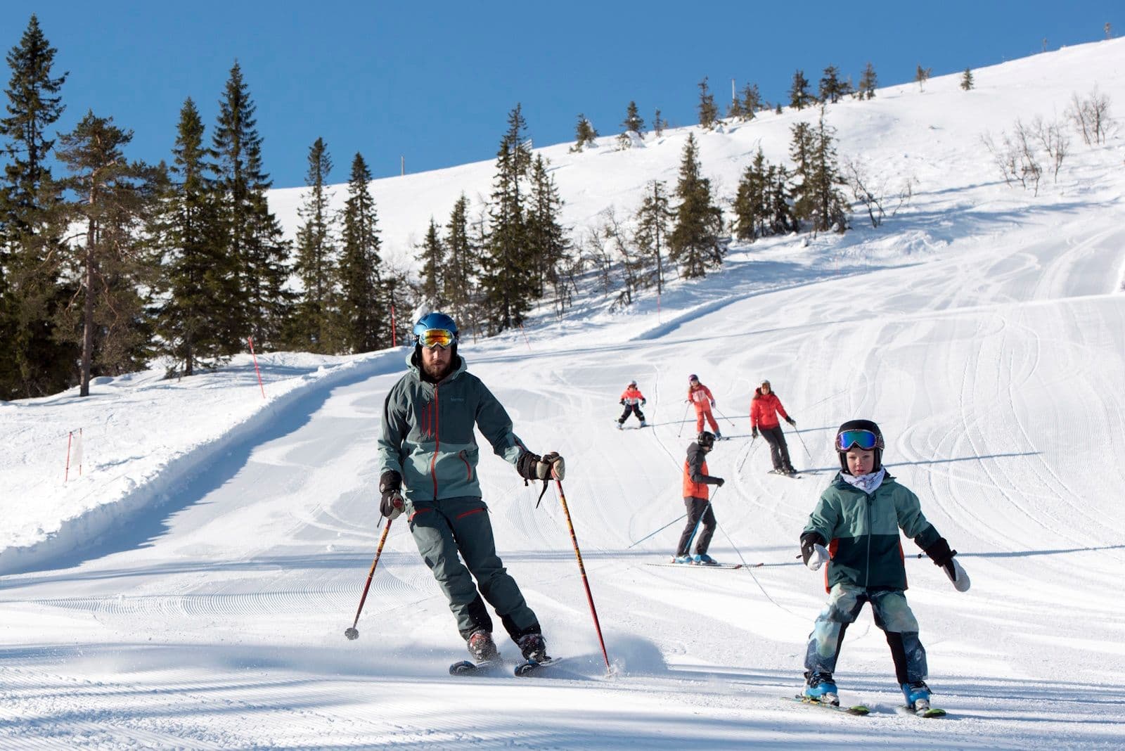 Kungsberget in Sweden - a group of people skiing down a snow covered hill.