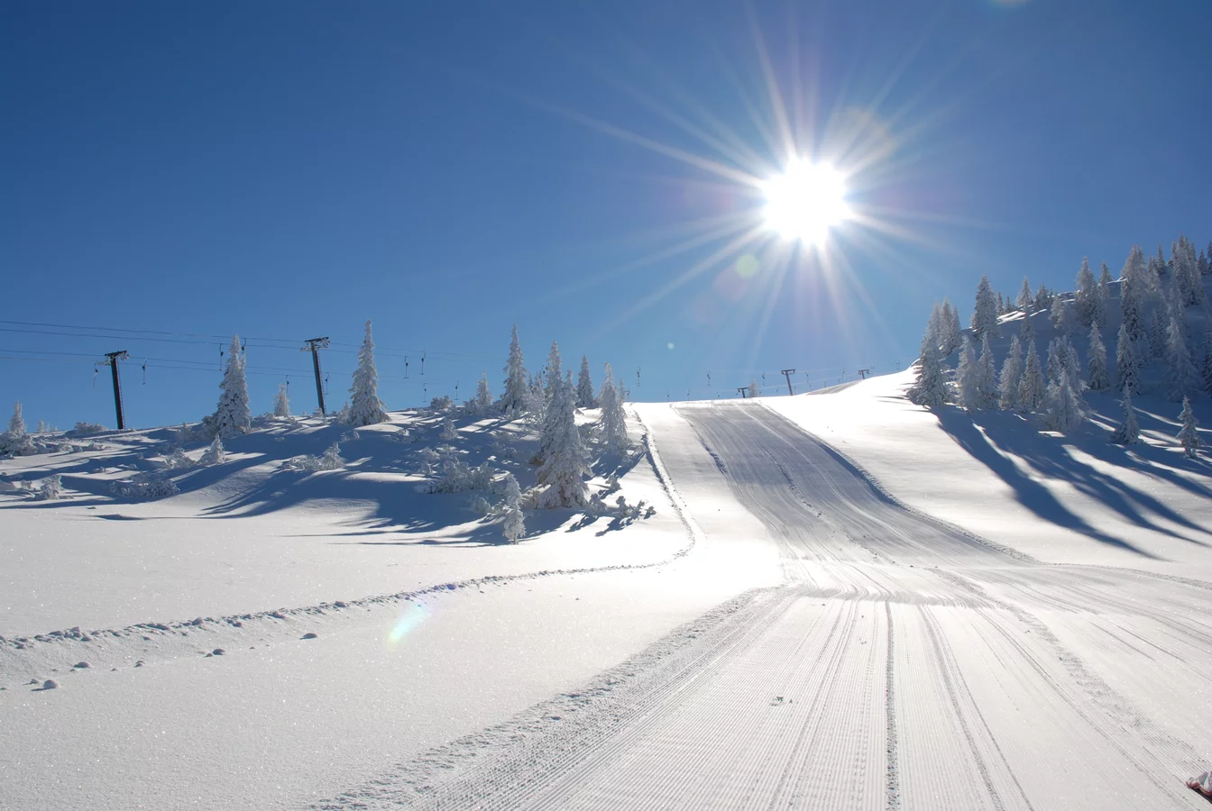Winter sports enthusiasts enjoy a day at Fageralm-Forstau ski resort in Pongau, Austria. A charming chalet nestled amid stunning winter scenery completes the picturesque view.