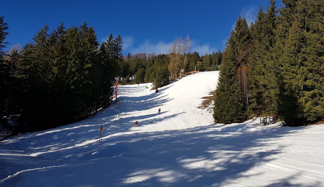 Winter sports scene at a ski resort in Annaberg Mostviertel Austria including a cozy challet bustling winter sports centre and a skier enjoying the snowy slopes.