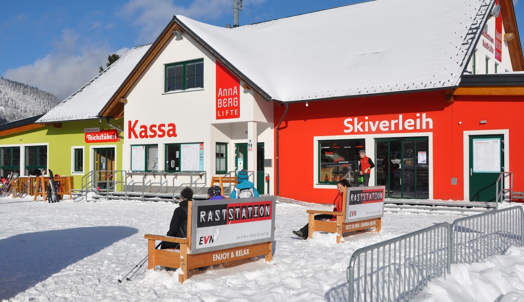 A winter sports centre in Annaberg Mostviertel Austria. The scene showcases a bustling ski resort with a ski lift in the backdrop. Skiers prepare for bolstering runs amidst the serene snow-covered landscape.