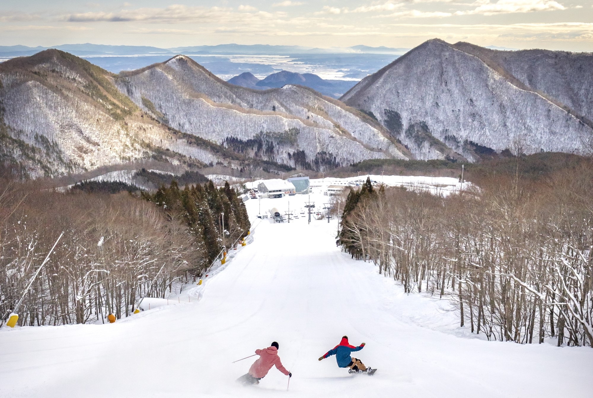 Skier enjoying a day at the Spring Valley Izumi Kogen ski resort in Tōhoku, Japan, surrounded by stunning winter scenery with snow-covered slopes and trees.