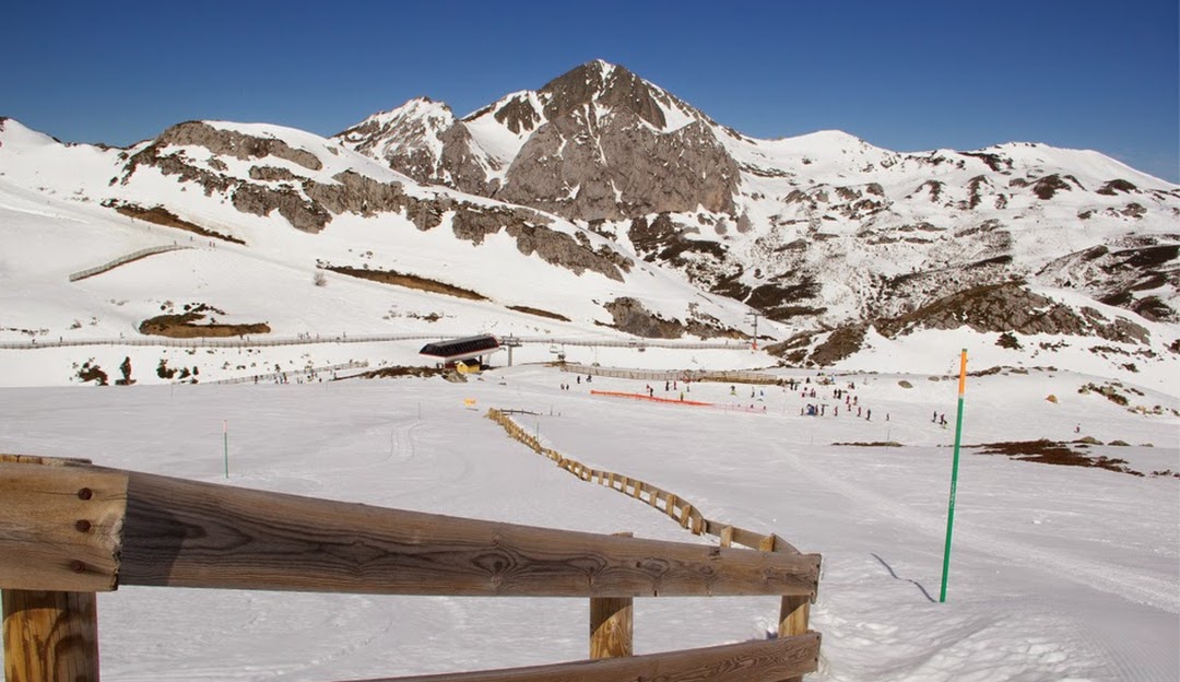 Image of Fuentes de Invierno, a winter sports centre in Asturias, Spain. The scene features an active ski resort with a chalet and ski lift in a snowy landscape.