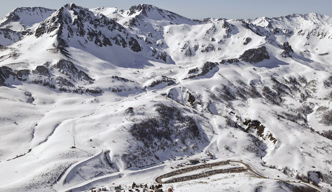 Ski resort in Fuentes de Invierno, Asturias, Spain with snow-covered slopes and a challet. A skier enjoys the winter sports scene on the mountain.