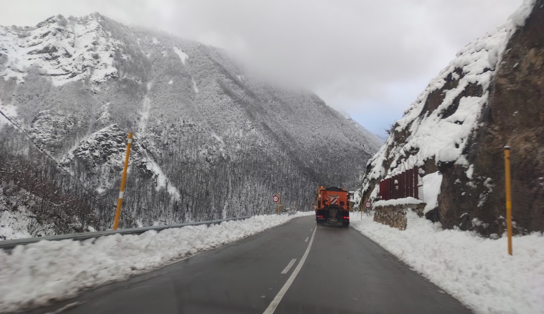 A beautiful winter scene at Fuentes de Invierno in Asturias Spain featuring snowy mountains skiers gliding down the slopes and a cozy chalet nestled at the foot of the mountain.