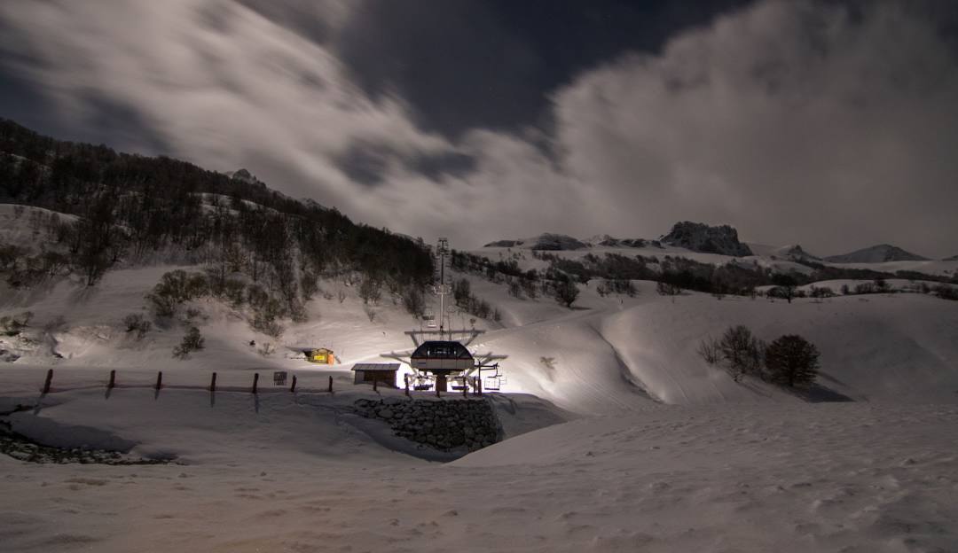 Winter scene at Fuentes de Invierno ski resort in Asturias, Spain, featuring snow-covered slopes, ski lifts, and stunning mountainous backdrop.