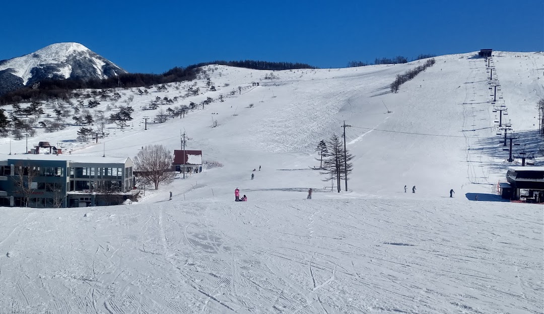Ski resort at Shirakabako Royal Hill in Nagano, Japan showcasing a picturesque winter scene with a chalet, ski lift, and enthusiasts enjoying winter sports.
