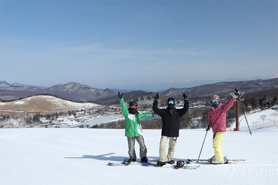 Winter sports scene at Shirakabako Royal Hill in Chūbu, Japan, showing a family and group of people skiing at the resort amid snowy landscape.