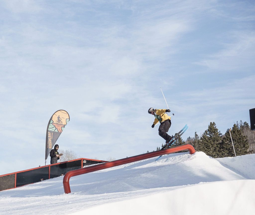 A skier and a snowboarder enjoying a winter sports scene at Sugarloaf Provincial Park, a ski resort in Atholville, New Brunswick, Canada.