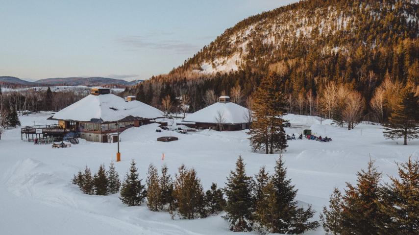 Winter scene at Sugarloaf Provincial Park in Atholville, New Brunswick, showcasing ski resort facilities set amidst breathtaking snowy landscape, hosting various winter sports activities.