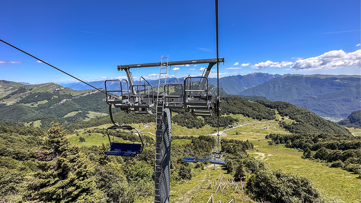 Prà Alpesina Chairlift - Upper terminal in Italy - a cable car on a mountain with a view of mountains.