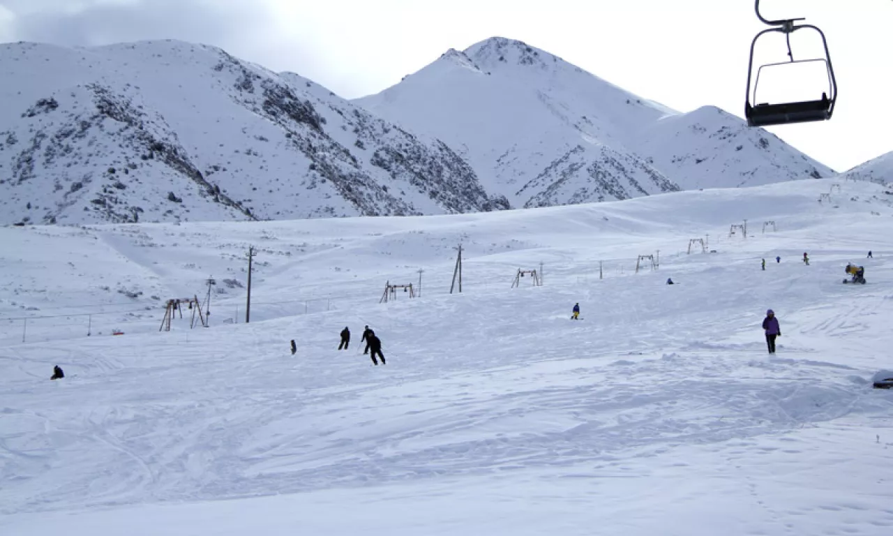Zil Ski Base in Kyrgyzstan - a group of people skiing down a snowy mountain.