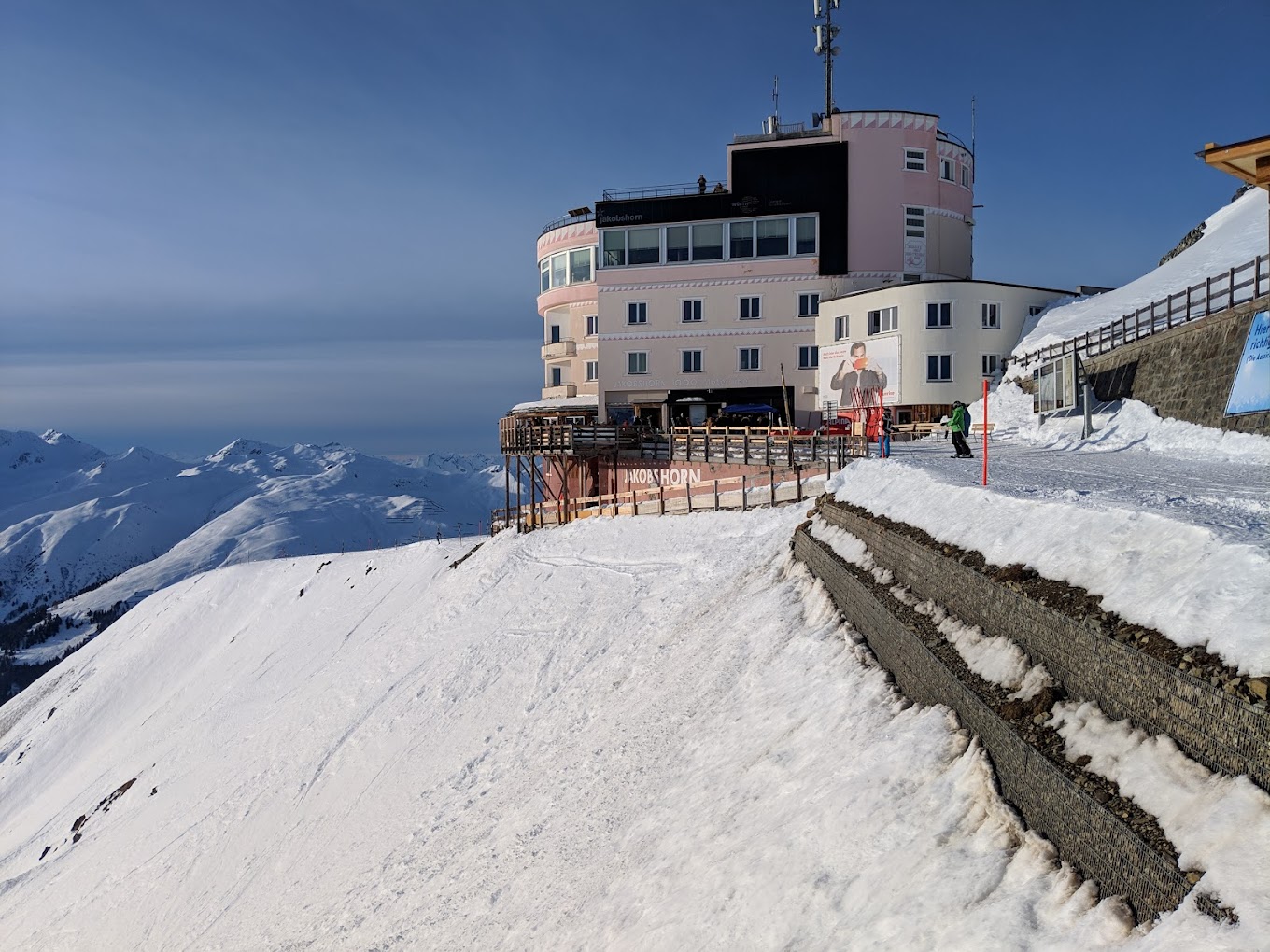 A picturesque Swiss ski resort at Jakobshorn in Graubünden featuring a cabin-like mountain hut a ski lift and a vibrant winter sports scene.