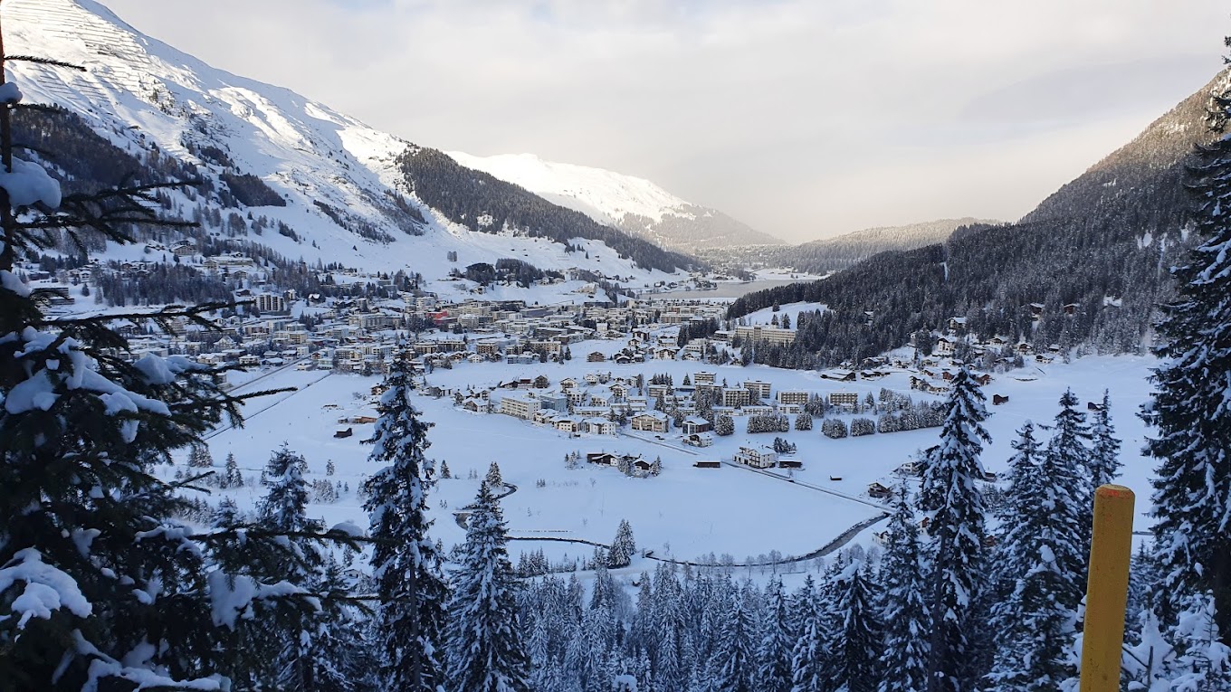 Winter scene at Jakobshorn ski resort in Eastern Switzerland, featuring skiers enjoying the slopes, a picturesque chalet, and stunning snow-covered scenery.
