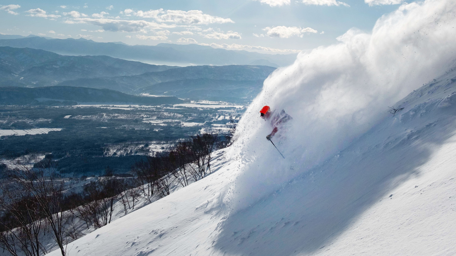 Yamaboku – Yamada Bokujo in Japan - a person skiing down a snowy slope in the mountains.