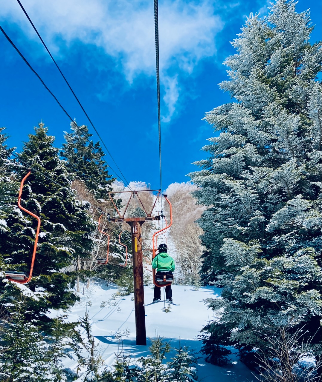Yamaboku – Yamada Bokujo in Japan - a person riding a ski lift in the snow.