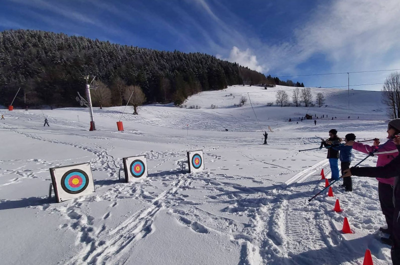 Winter sports scene at Lans en Vercors in Isère, Grenoble, France, featuring a sports centre, a scenic chalet, and a skier at the ski resort.
