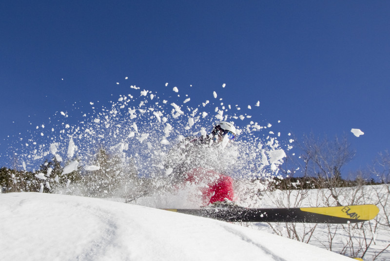 Winter sports enthusiasts enjoying a day on the slopes in Lans en Vercors, France, with skiers and a snowboarder gliding down the mountain.
