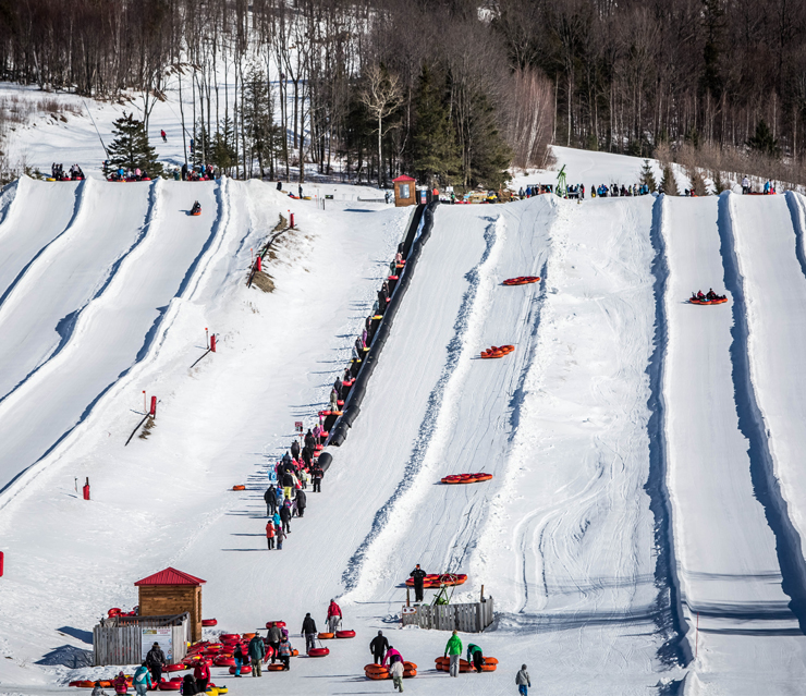 Winter scene at Mont Gleason in Tingwick, Quebec, Canada, showing a bustling ski resort with numerous skiers enjoying the snowy slopes.