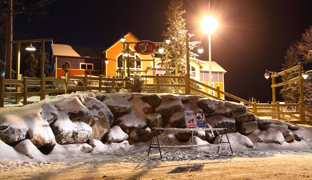 A winter sports scene at Mont Gleason ski resort in Tingwick, Quebec, Canada, featuring a ski lift and a skier enjoying the snowy slopes.