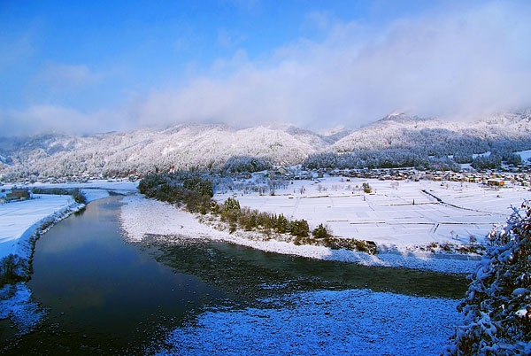 Panoramic view of the breathtaking winter landscape in Greenpia Tsunan, Japan. The captivating scene showcases a chalet amidst the snow-covered terrain, a perfect backdrop for winter sports.