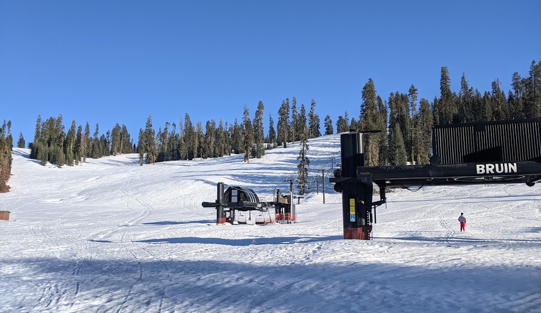 View of the ski lift at Badger Pass in Yosemite National Park, dotted with skiers enjoying winter sports amid the snow-covered resort.