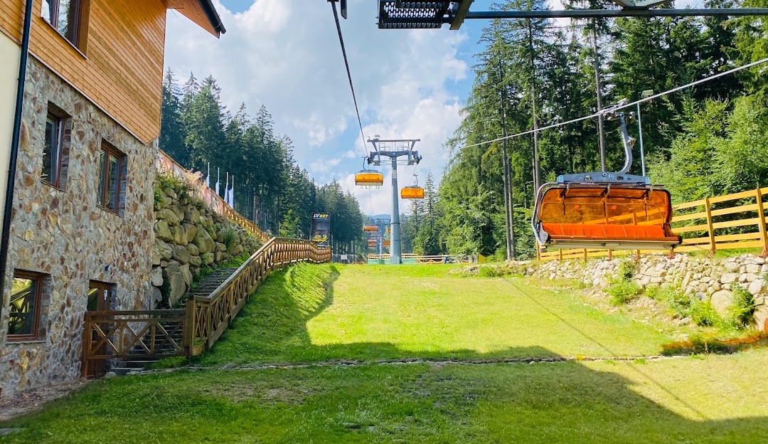Ski lift ascending the slopes at Winterpol White Jar in Karpacz, Poland. The ski resort features a charming chalet nestled amid the crisp, sunlit snow-capped environment.