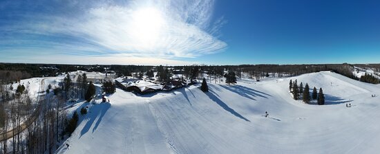Winter sports enthusiasts enjoying a day at the ski resort in Otsego, Gaylord, Michigan. Snow-covered slopes and a cozy chalet complete the stunning winter scenery.