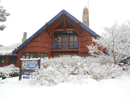 A wintry scene at Otsego Gaylord Michigan featuring a bustling winter sports centre. Nearby a lodge and ski resort imply ongoing activities while a chalet suggests cozy accommodations.