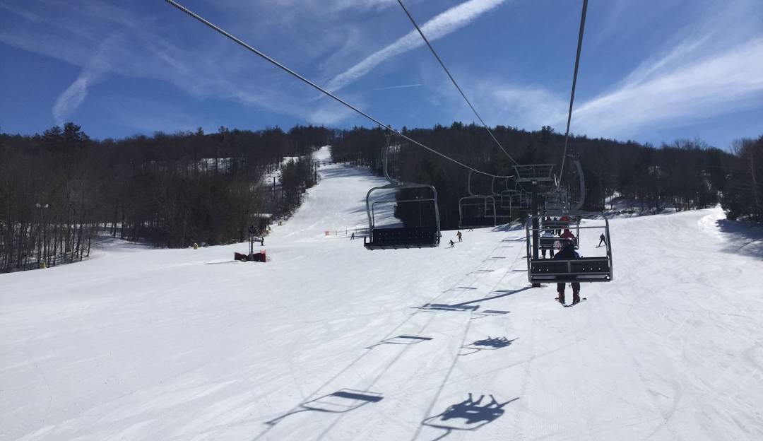 A beautiful winter scene at Mohawk Mountain Ski Resort in Connecticut featuring a ski lift in operation a skier on snow-covered slopes embodying the excitement of winter sports.