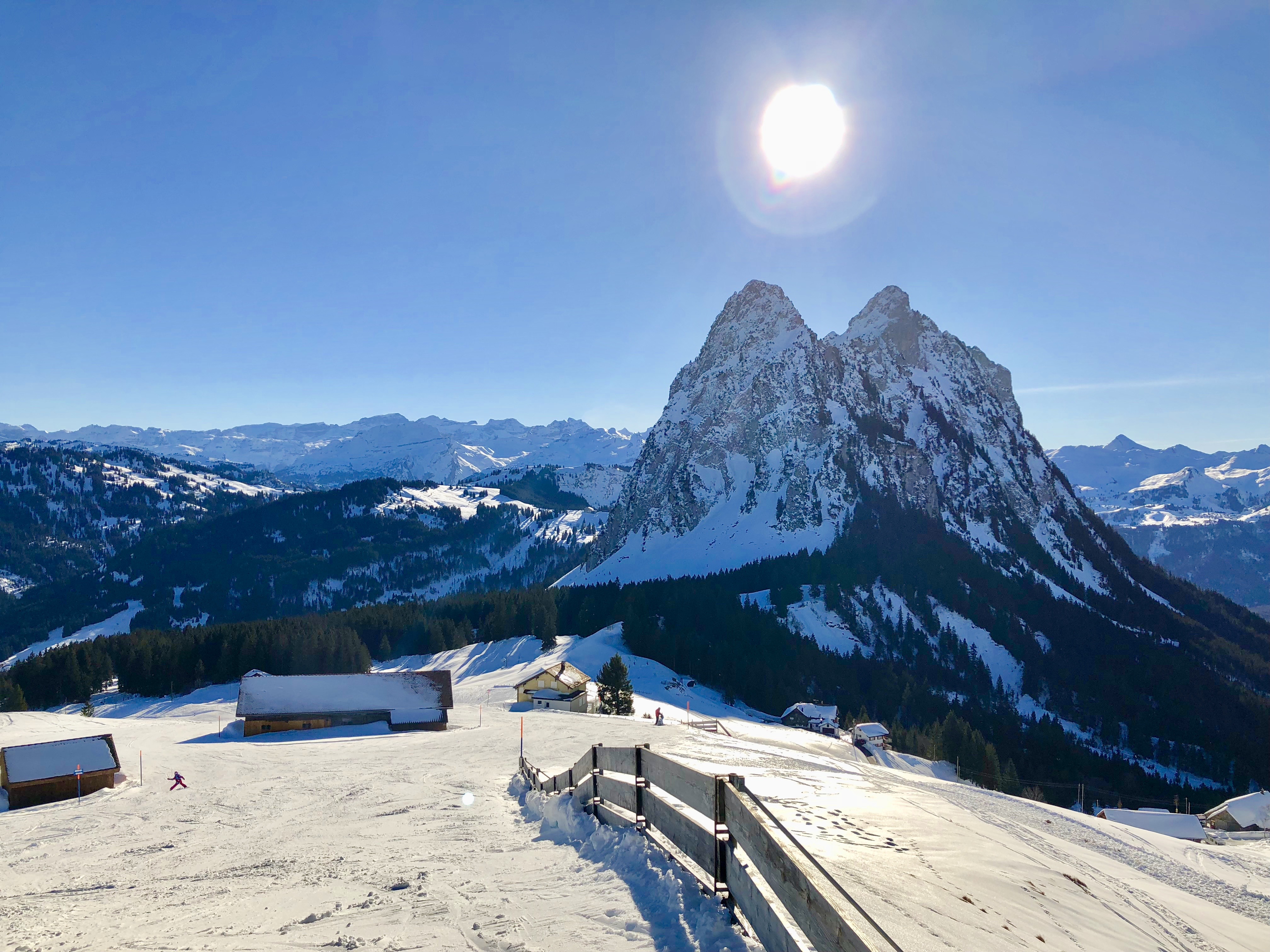 Winter sports scene at Brunni-Bahnen, Engelberg-Titlis, showcasing a vibrant winter sports centre against the backdrop of a majestic mountain, wrapped in stunning winter scenery.