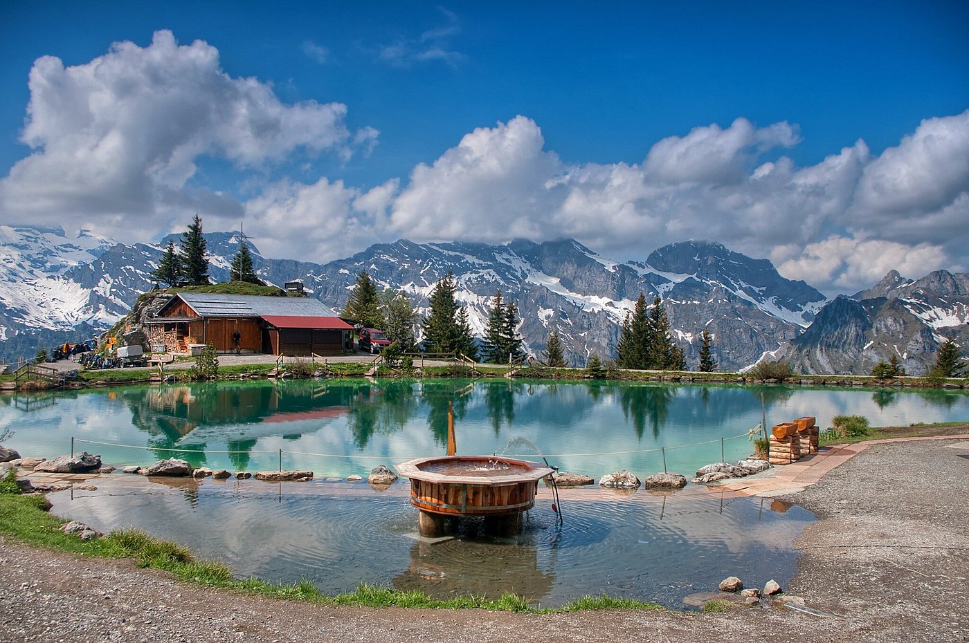 Breathtaking view of Brunni-Bahnen ski resort in Engelberg, Switzerland. Features include a stunning lake amidst snow-capped mountains, a bustling ski lift, and a cozy lodge.