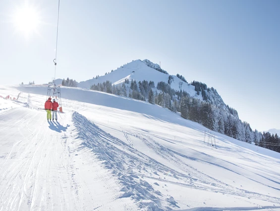 Winter sports scene with a skier at Grüntenlifte – Kranzegg in Oberallgäu, Bavaria, Germany. Also present a ski resort with a charming challet, and a ski lift.