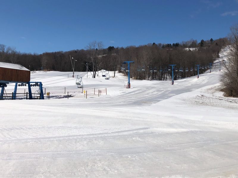 A winter sports scene at a ski resort in Buffalo Greater Niagara Colden New York USA featuring a skier nearing a ski lift amidst the snow-covered landscape.