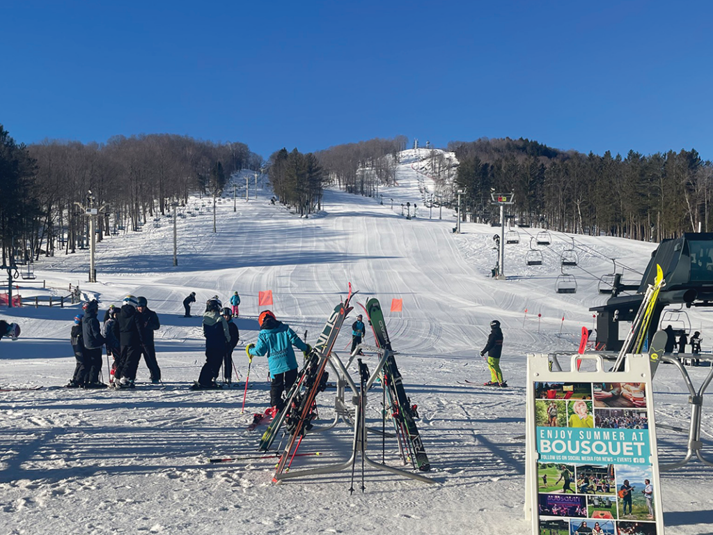 Bousquet in USA - a group of people standing on top of a ski slope.
