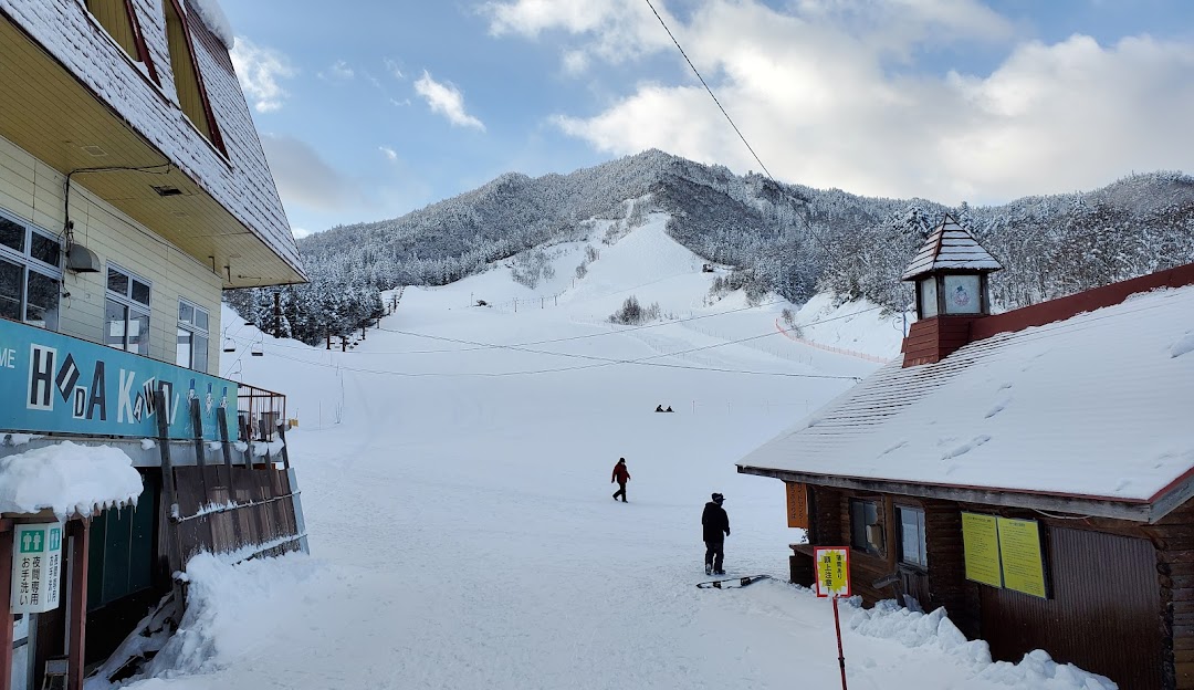 A picturesque winter scene from Hida Kawai, Japan, showcasing a bustling ski resort nestled in a stunning snowy landscape, complete with a charming chalet and numerous winter sports enthusiasts.
