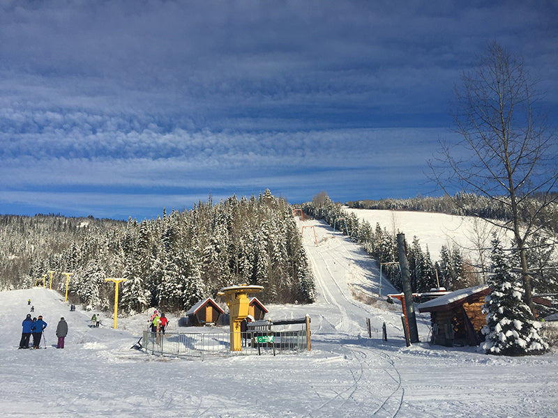 Winter sports scene at Troll Ski Resort in Quesnel, British Columbia, featuring a ski lift and snow-covered slopes against a striking winter backdrop.