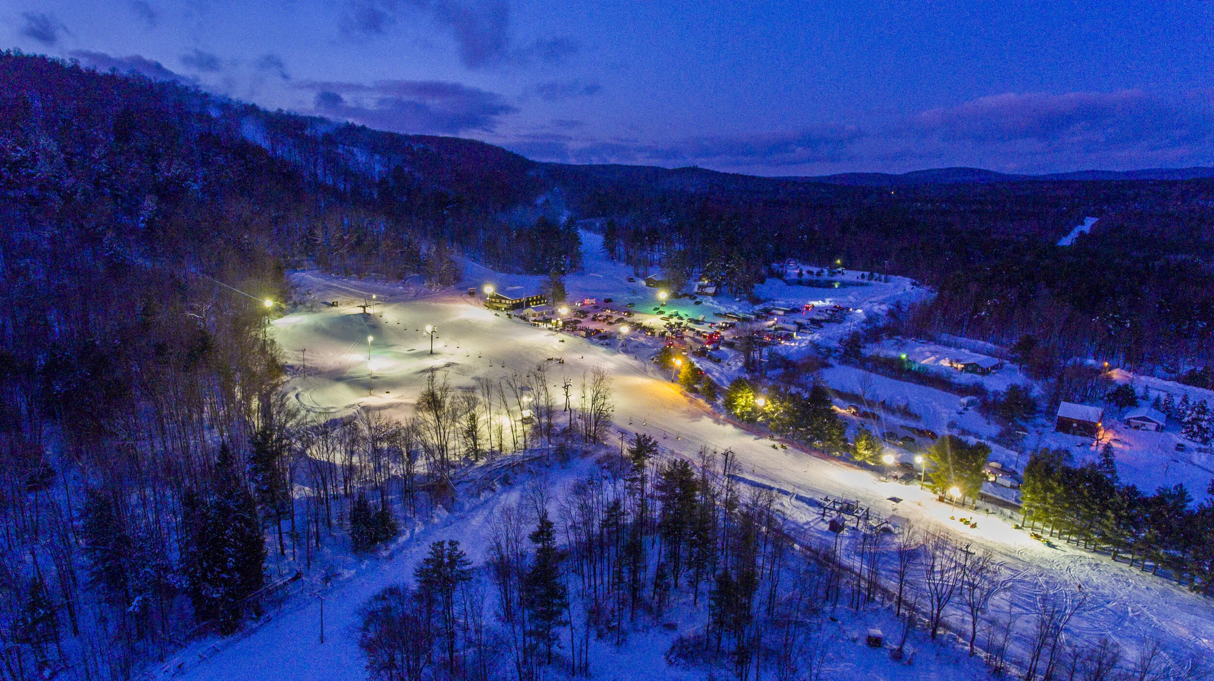 Winter sports enthusiasts enjoying their time at the Royal Mountain Ski Resort in Johnstown, New York, amidst an enchanting winter scenery.
