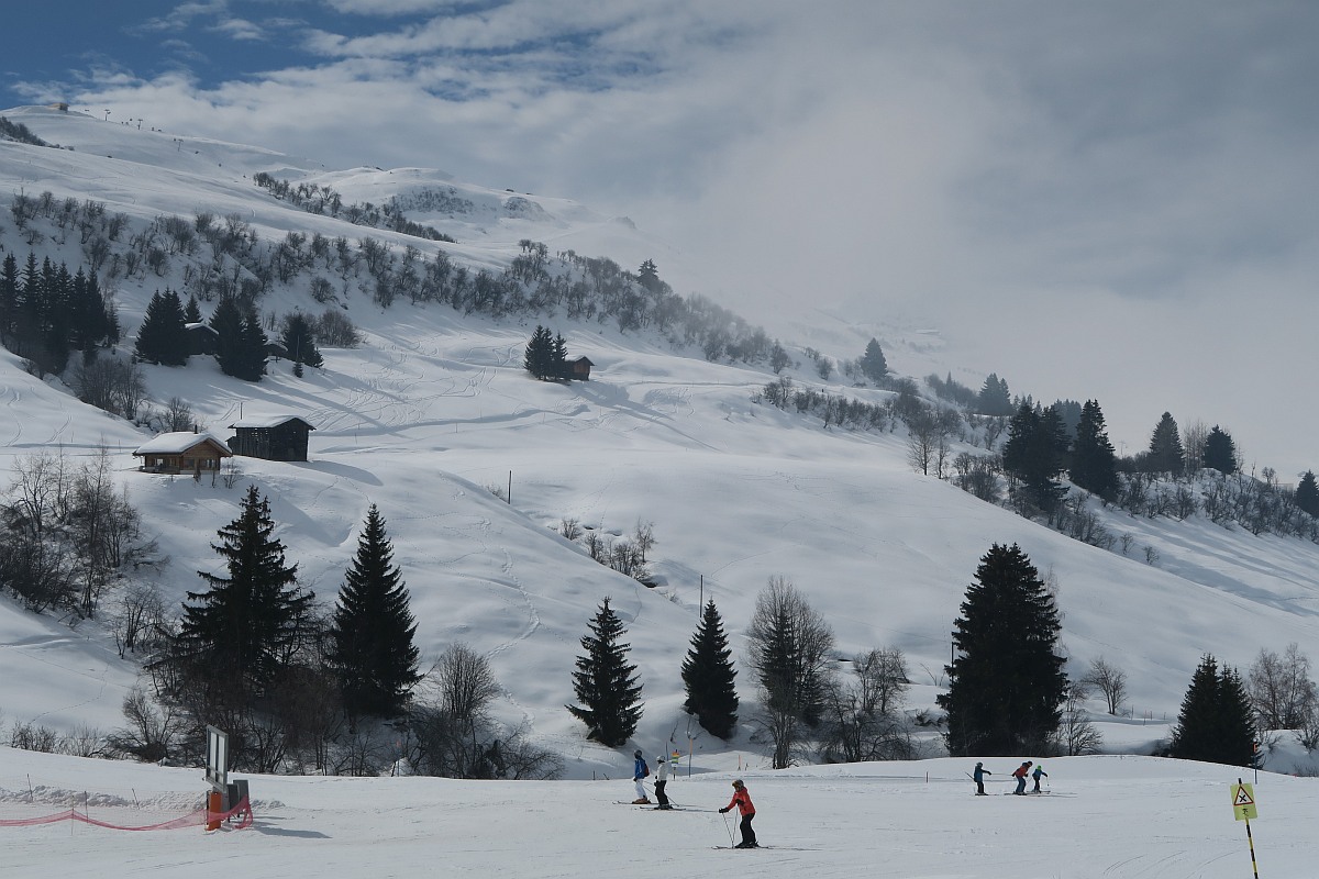 Obersaxen | Mundaun | Val Lumnezia in Switzerland - a group of people skiing down a snow covered mountain.