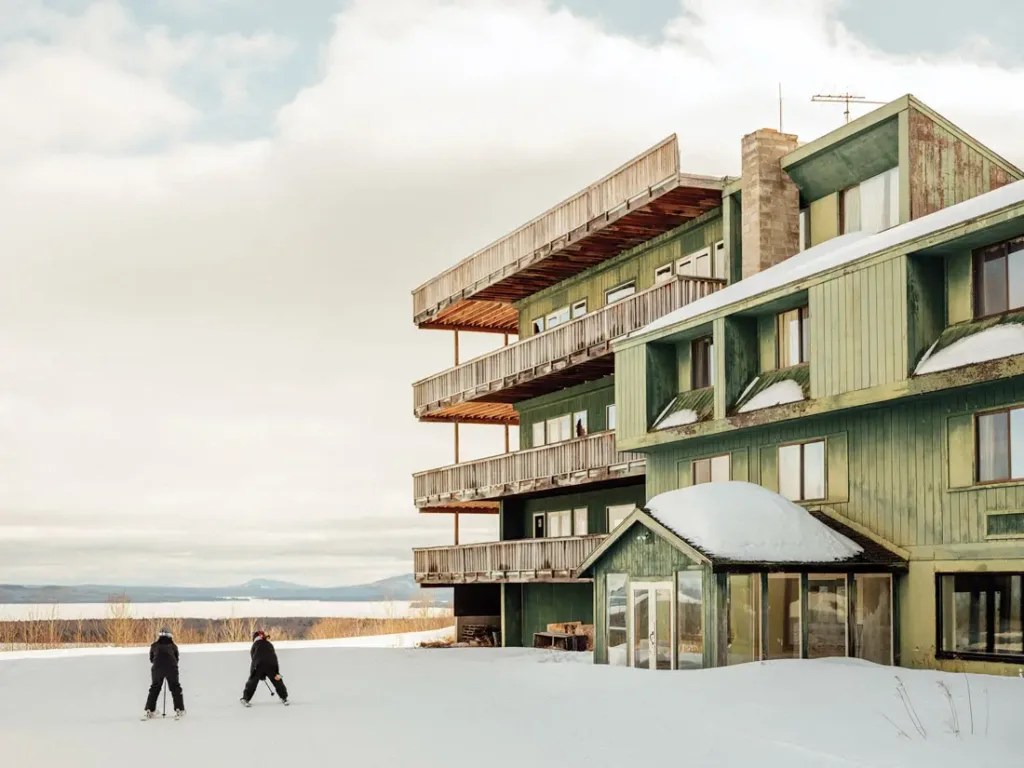 Big Moose Mountain in USA: a person walking in the snow next to a building.